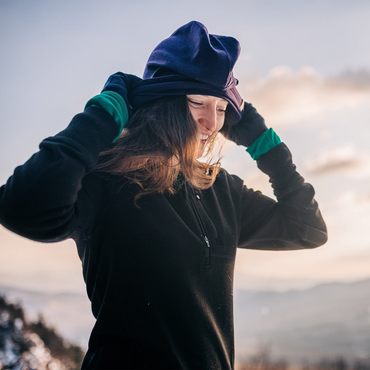 on top of a mountain cold weather gear woman with balaclava glove liners crew neck and quarter 1/4 zip merino wool