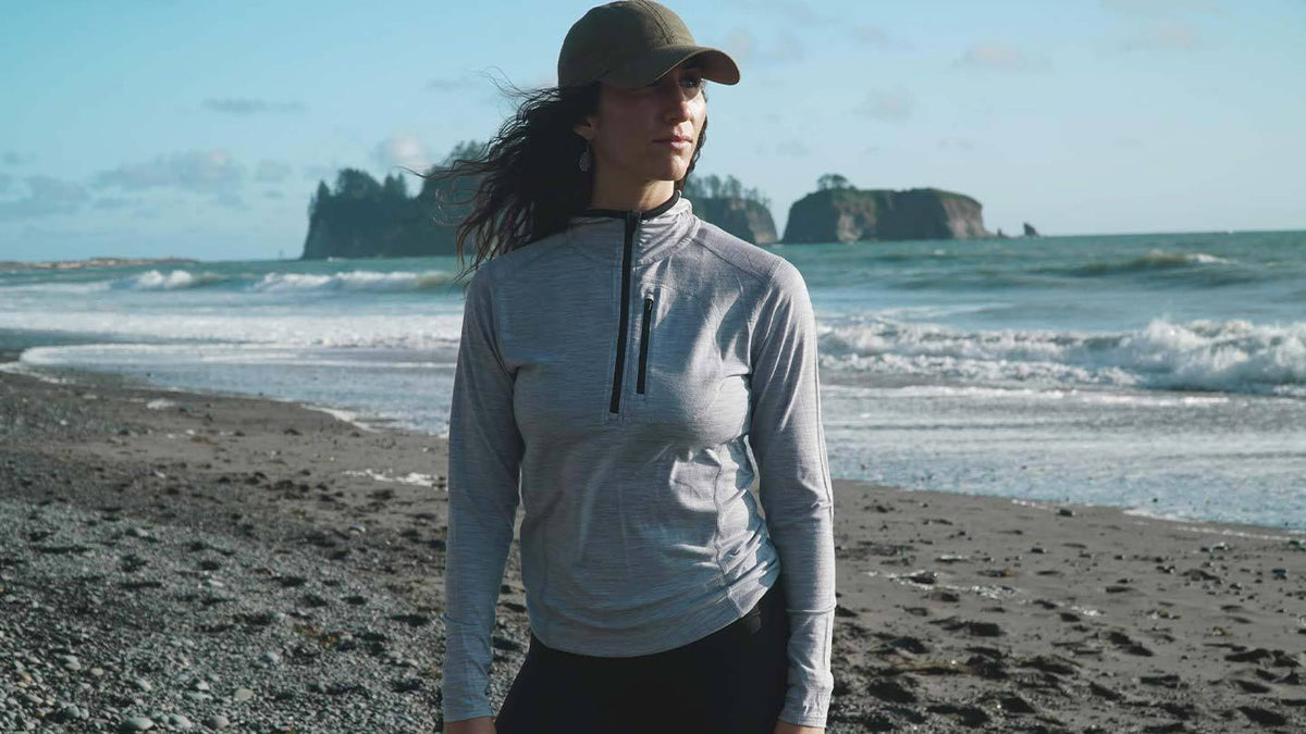 woman on beach wearing minus33 merino wool micro 1/4 zip hoodie shirt