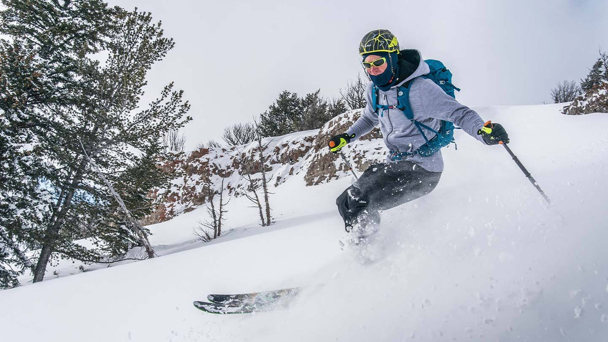man skiing and wearing minus33 merino wool expedition hoodie sweatshirt and midweight balaclava