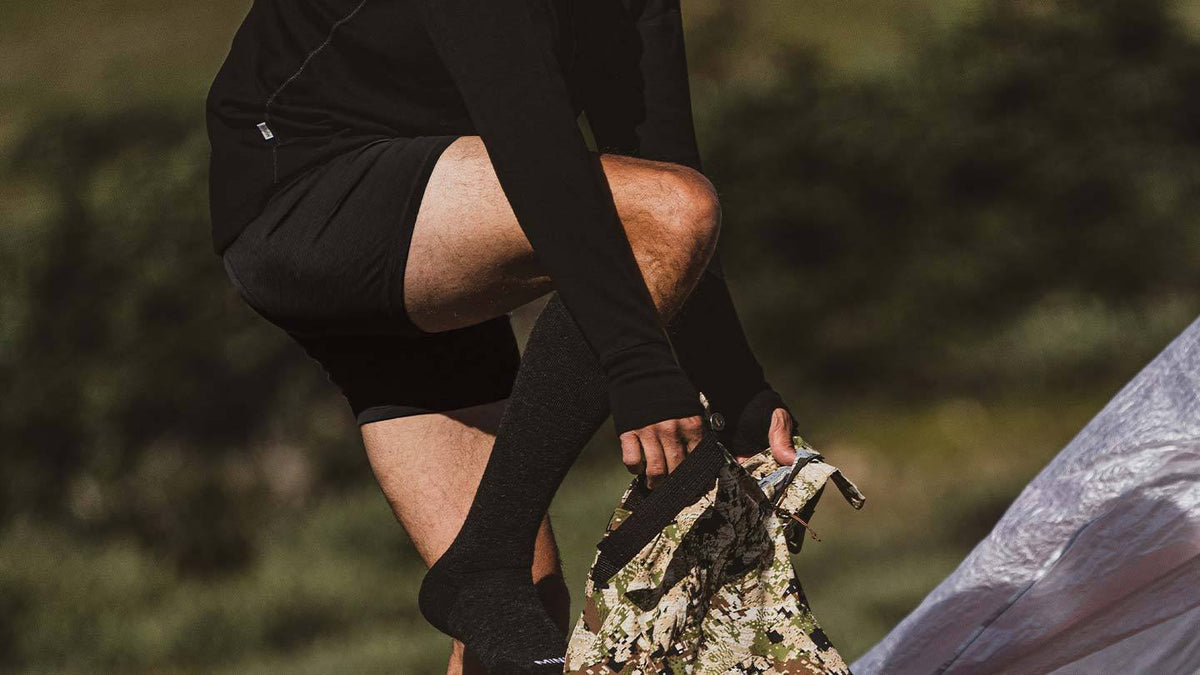 man putting on pants while wearing minus33 merino wool lightweight boxer brief underwear