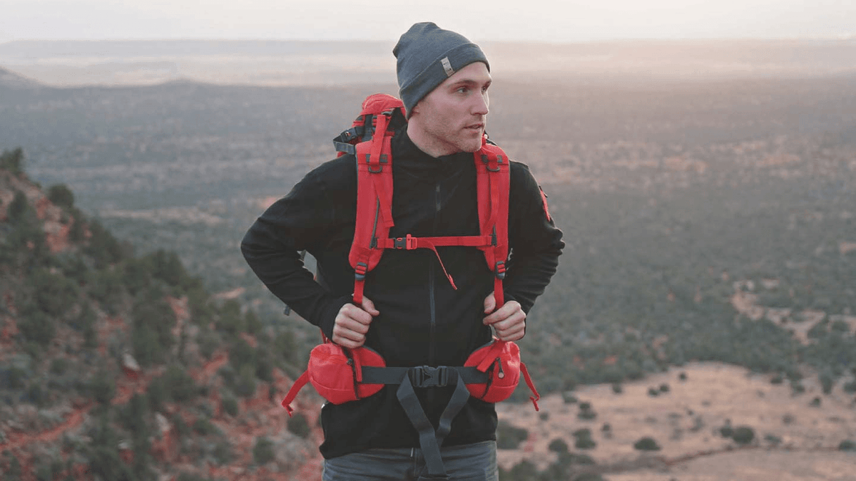 man hiking in arizona while wearing minus33 merino wool mid layer shirt and beanie