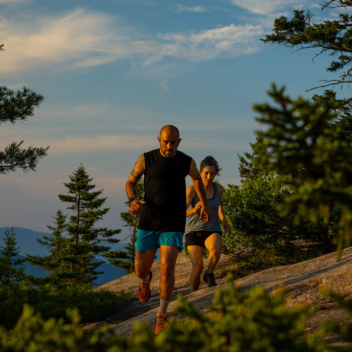 Couple running through the mountain white mountains new hampshire base layer merino wool minus33 tank top shorts breathable socks 