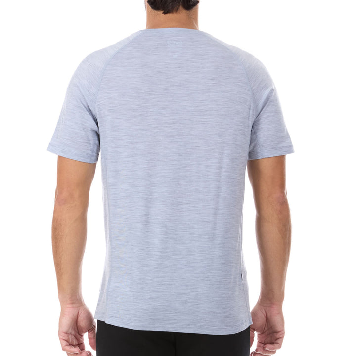 A man models the microweight Merino wool t shirt, your perfect choice for hitting the gym or setting foot on the trails. Raglan sleeves and side panels create a garment that moves with you, back view 