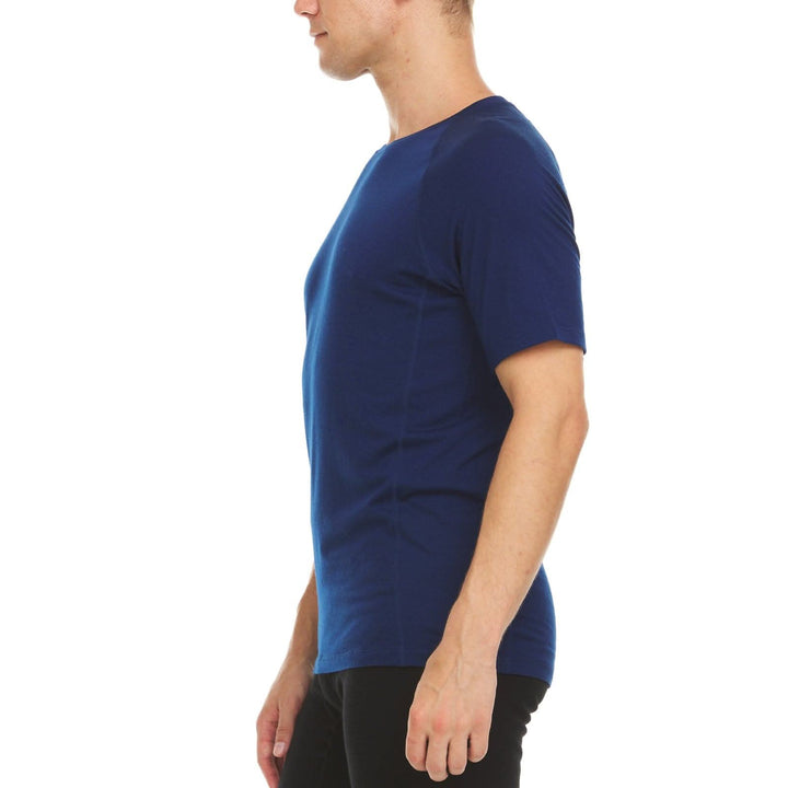 A man models the microweight Merino wool t shirt, your perfect choice for hitting the gym or setting foot on the trails. Raglan sleeves and side panels create a garment that moves with you 