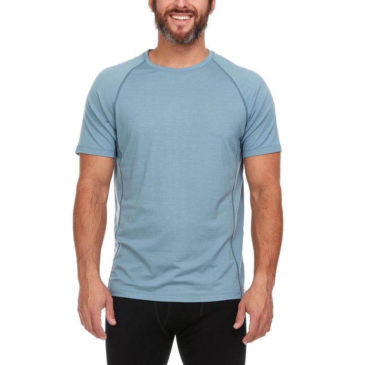 A man models the microweight merino wool t shirt, your perfect choice for hitting the gym or setting foot on the trails. Raglan sleeves and side panels create a garment that moves with you 