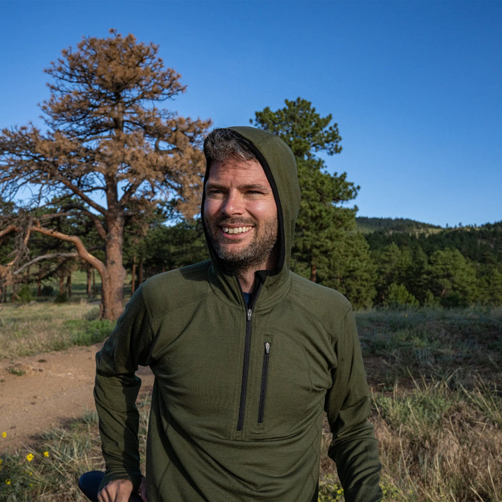 A man walks the trail in his super light microweight merino wool quarter zip sun hoodie.  