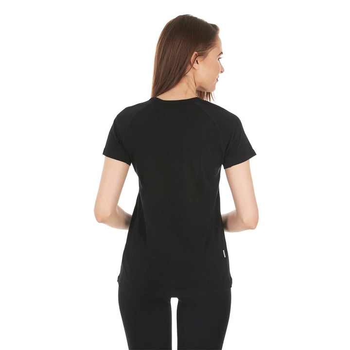 Back view of a woman wearing a black micro weight merino wool short-sleeve V-neck T-shirt, showing the rear neckline, shoulder seams, fitted sleeves, straight back panel, and smooth hem 