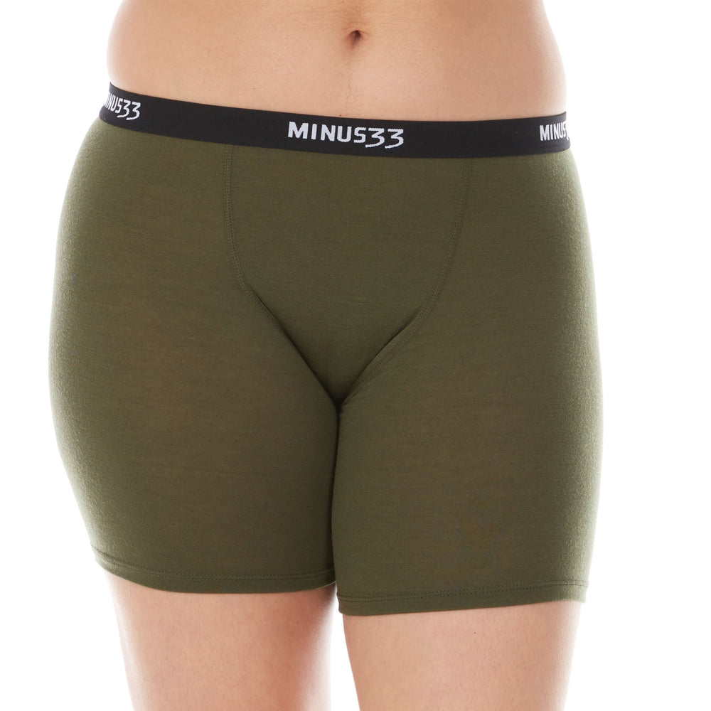 A woman models the microweight merino wool women's boxer briefs. The boxer briefs have a five inch inseam and a one inch woven sport elastic waistband, front view #color_olive-drab-green