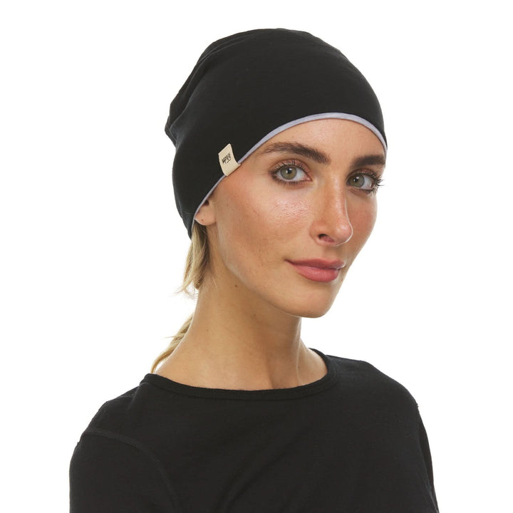 Side profile view of a male model wearing an ash gray and black reversible merino wool blend beanie 