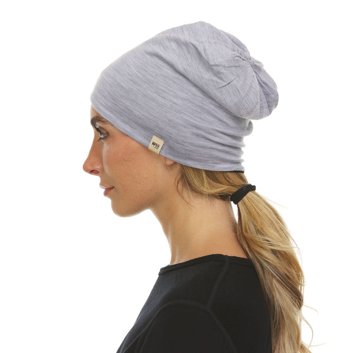 Alternate side view of a male model wearing an ash gray and black reversible merino wool blend beanie 