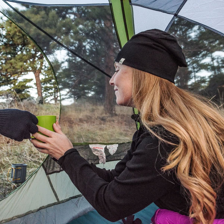 A woman models the super lightweight reversible beanie. This merino wool blend beanie is slim enough to fit under a helmet, but warm enough to wear by itself on a chilly run.
