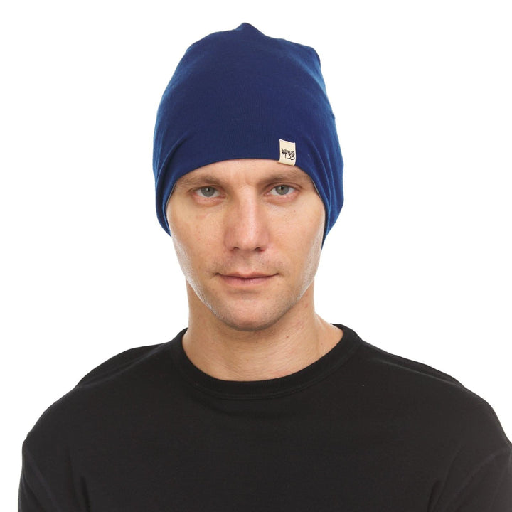 Front view of a male model wearing a navy and slate blue reversible merino wool blend beanie 