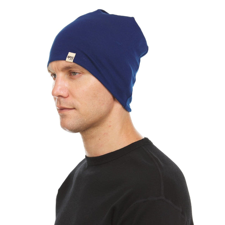 A man models the super lightweight reversible beanie. This merino wool blend beanie is slim enough to fit under a helmet, but warm enough to wear by itself on a chilly run.
