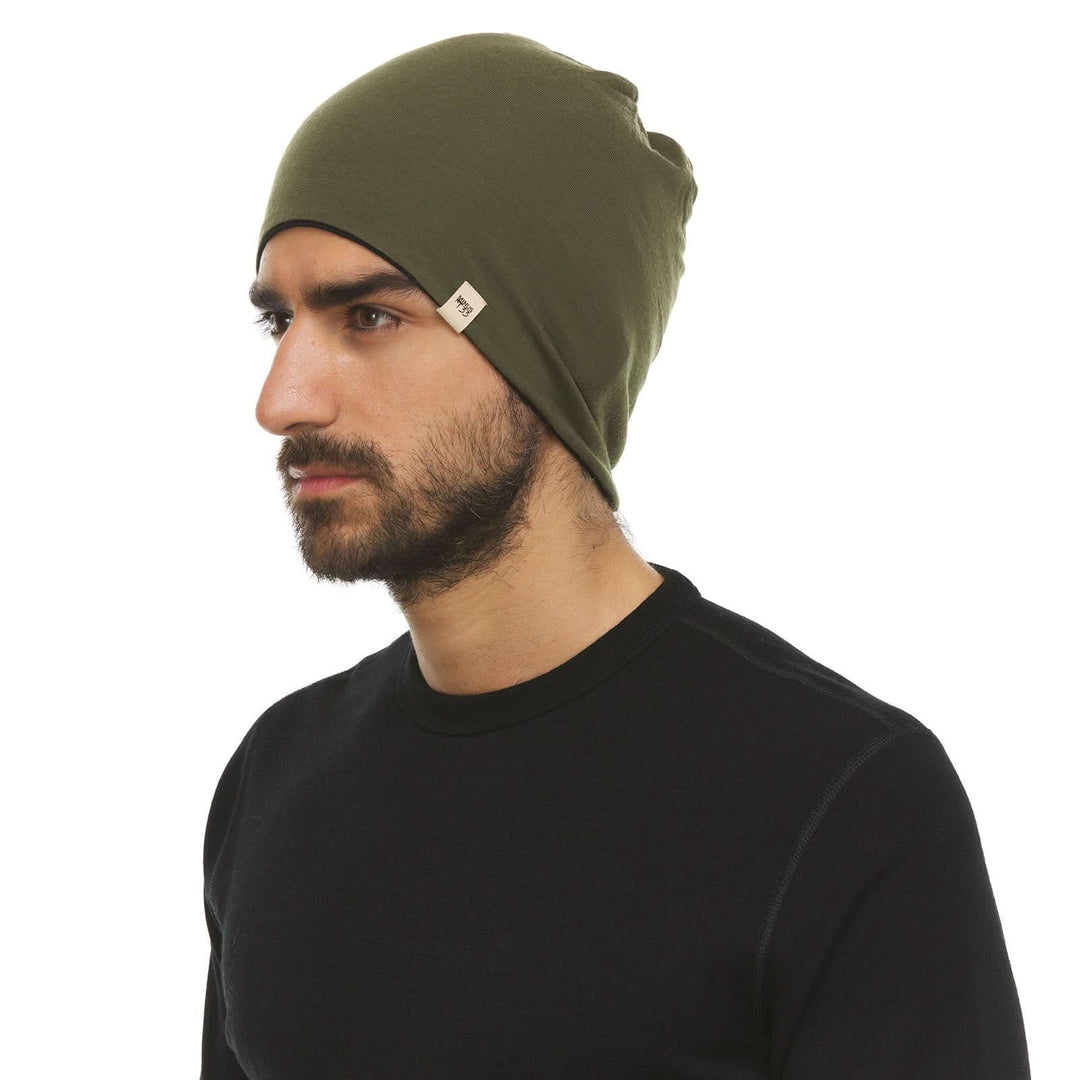 A man models the super lightweight reversible beanie. This merino wool blend beanie is slim enough to fit under a helmet, but warm enough to wear by itself on a chilly run.
