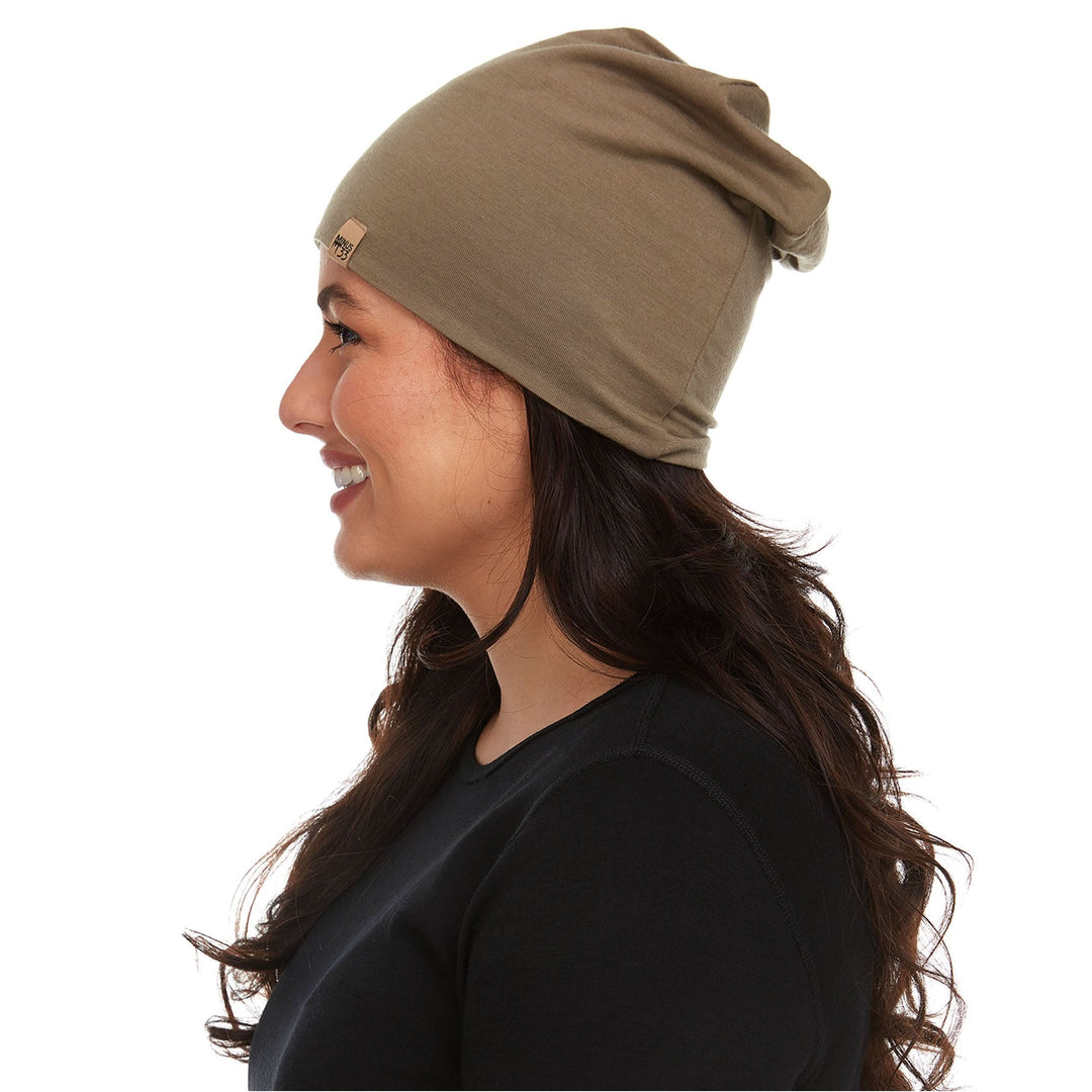 A woman models the super lightweight reversible beanie. This merino wool blend beanie is slim enough to fit under a helmet, but warm enough to wear by itself on a chilly run.

