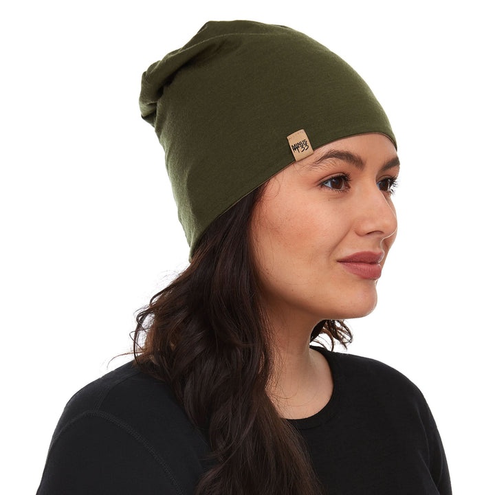 Side profile view of a male model wearing the tan side of an olive drab reversible merino wool blend beanie 