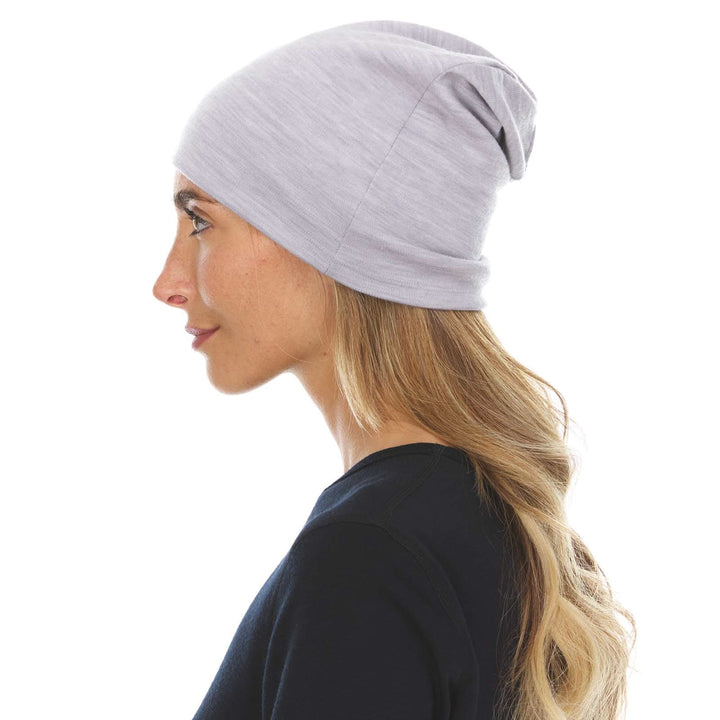 A woman models the lightweight, double-layered, hundred percent, super soft merino wool beanie perfect for fall, winter, and spring. This hat is perfect for a hike up the mountain or a walk around the block, right-facing side view 