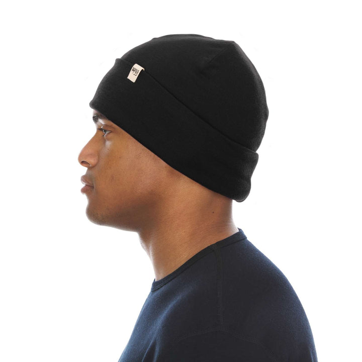 A man models the lightweight, double-layered, hundred percent, super soft merino wool beanie perfect for fall, winter, and spring. This hat is perfect for a hike up the mountain or a walk around the block, right-facing side view 