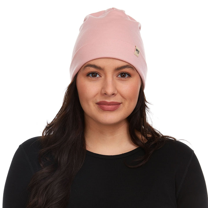 Front view of a female model wearing a blush pink lightweight double-layer 100% merino wool beanie 