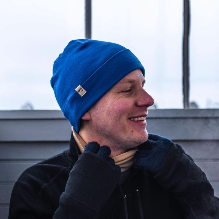 A man models the lightweight, double-layered, hundred percent, super soft merino wool beanie perfect for fall, winter, and spring. This hat is perfect for a hike up the mountain or a walk around the block!
