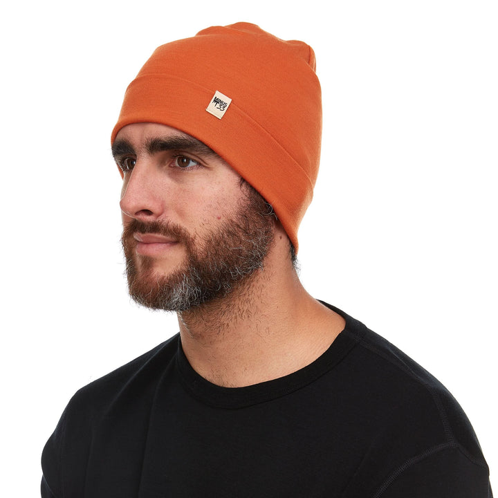 A man models the lightweight, double-layered, hundred percent, super soft merino wool beanie perfect for fall, winter, and spring. This hat is perfect for a hike up the mountain or a walk around the block, right-facing side view 