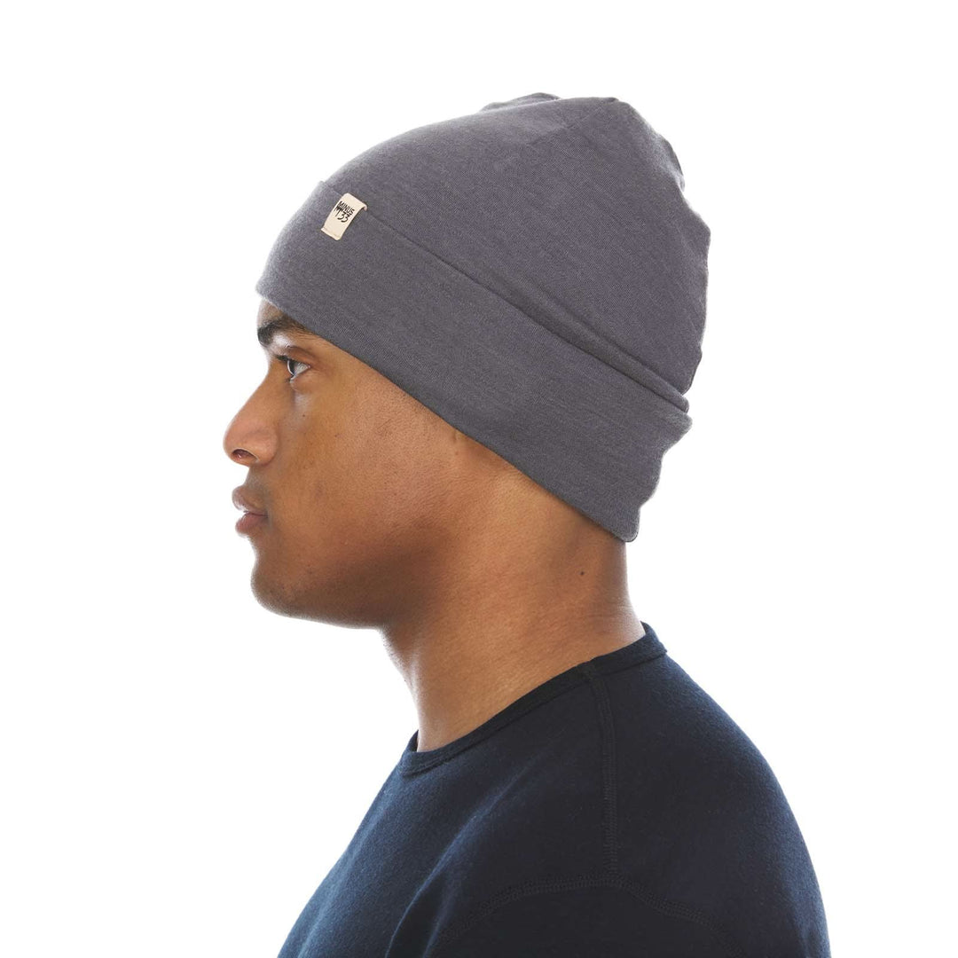 A man models the lightweight, double-layered, hundred percent, super soft merino wool beanie perfect for fall, winter, and spring. This hat is perfect for a hike up the mountain or a walk around the block, right-facing side view 