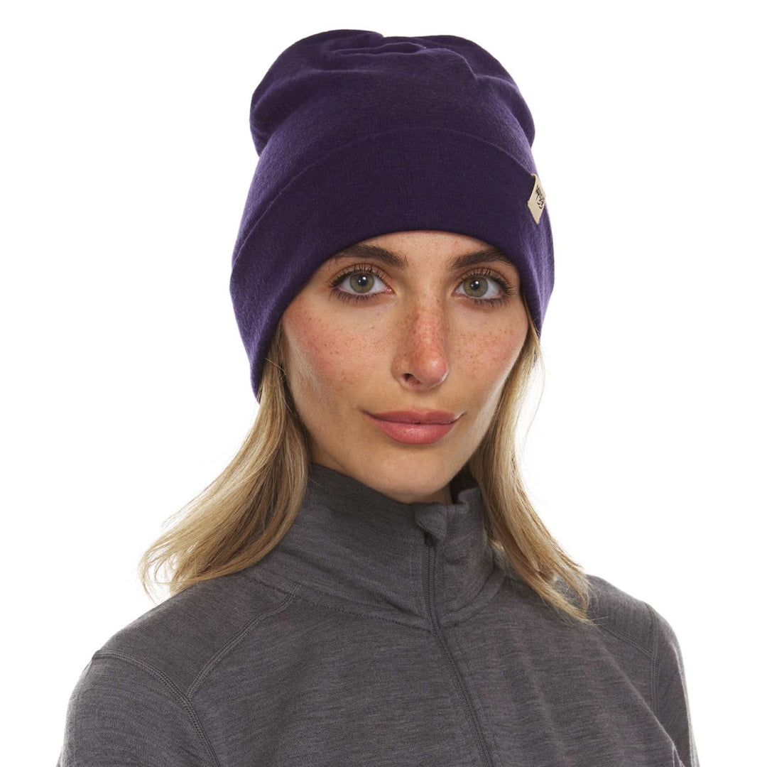 A woman models a lightweight, double-layered, hundred percent, super soft merino wool beanie perfect for fall, winter, and spring. This hat is perfect for a hike up the mountain or a walk around the block!
