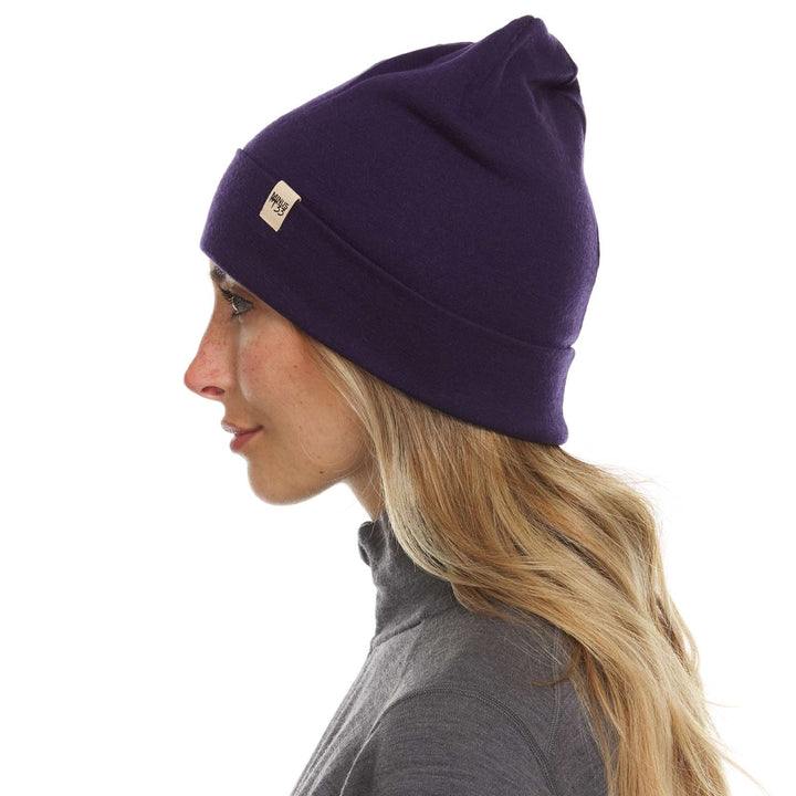 A woman models a lightweight, double-layered, hundred percent, super soft merino wool beanie perfect for fall, winter, and spring. This hat is perfect for a hike up the mountain or a walk around the block, right-facing side view 