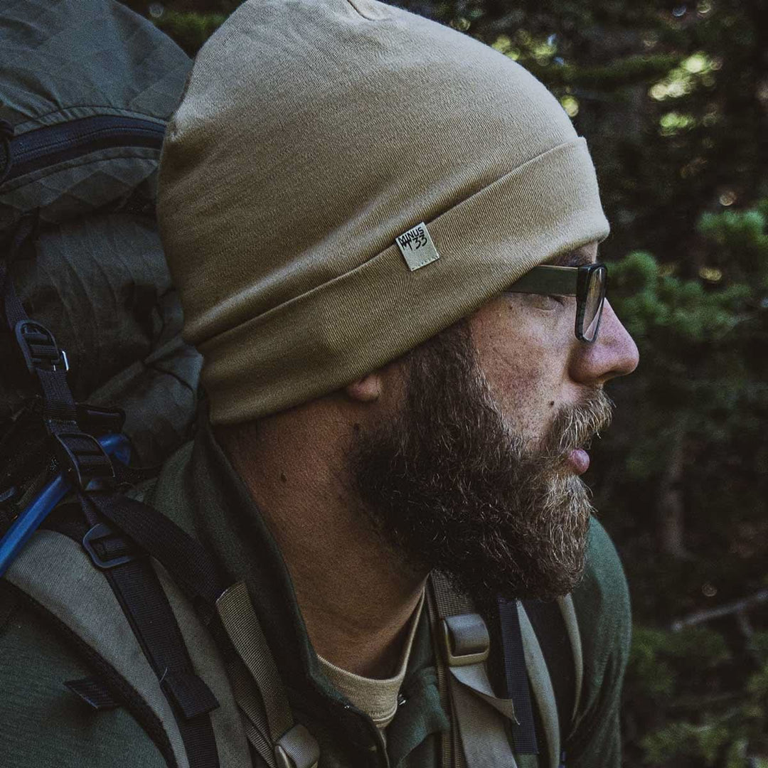 A man models the lightweight, double-layered, hundred percent, super soft merino wool beanie perfect for fall, winter, and spring. This hat is perfect for a hike up the mountain or a walk around the block, front view while hunting 