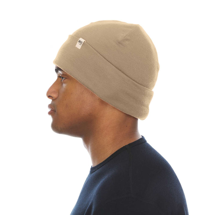 A man models the lightweight, double-layered, hundred percent, super soft merino wool beanie perfect for fall, winter, and spring. This hat is perfect for a hike up the mountain or a walk around the block, right-facing side view 