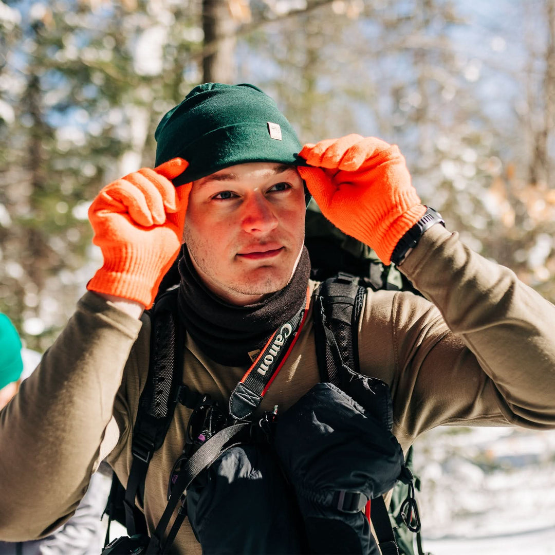A man models the lightweight, double-layered, hundred percent, super soft merino wool beanie perfect for fall, winter, and spring. This hat is perfect for a hike up the mountain or a walk around the block!
