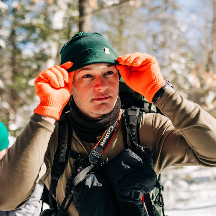 A man models the lightweight, double-layered, hundred percent, super soft merino wool beanie perfect for fall, winter, and spring. This hat is perfect for a hike up the mountain or a walk around the block!
