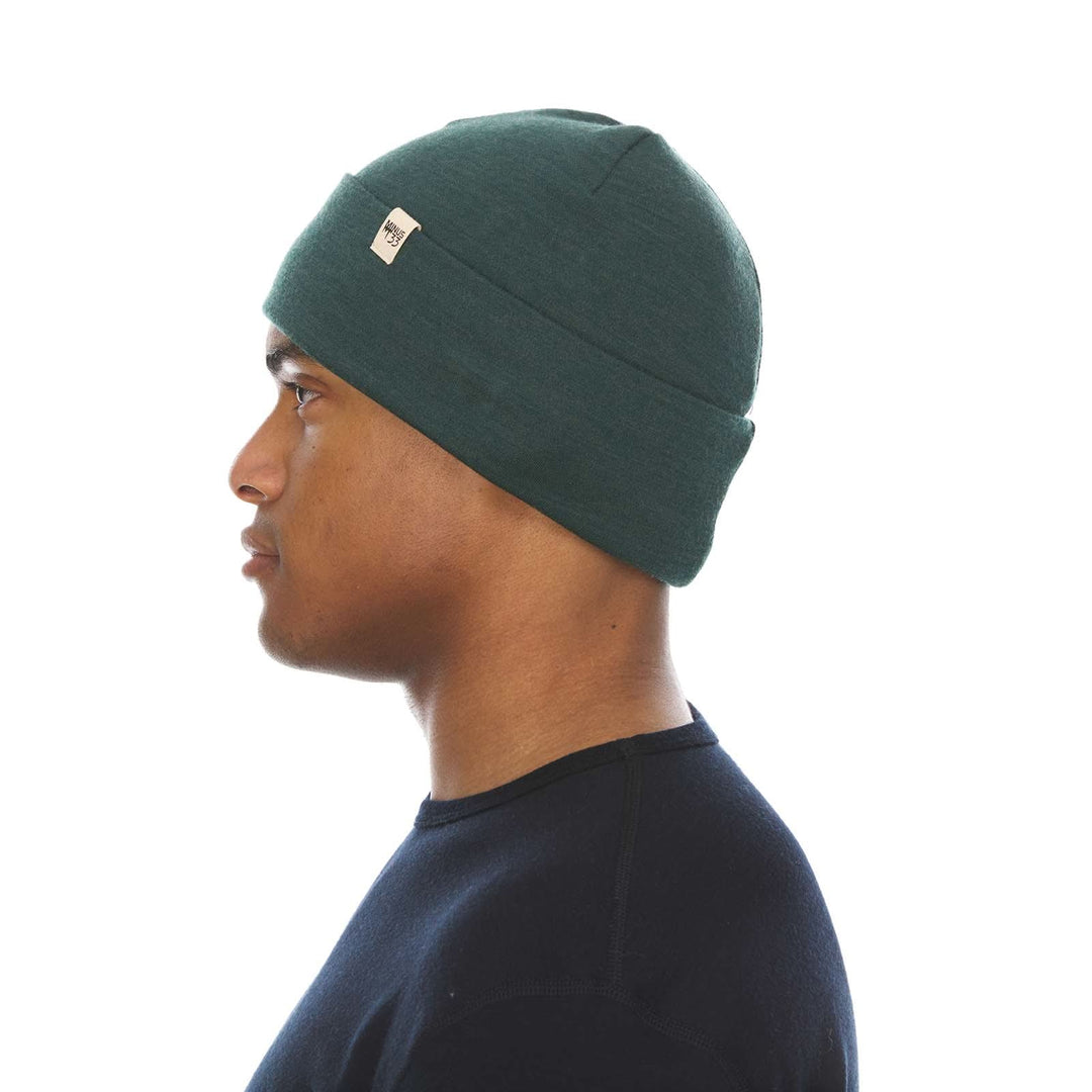 A man models the lightweight, double-layered, hundred percent, super soft merino wool beanie perfect for fall, winter, and spring. This hat is perfect for a hike up the mountain or a walk around the block, right-facing side view 