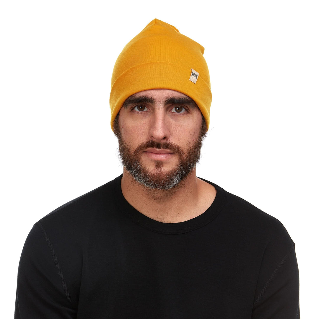Front view of a male model wearing a gold lightweight double-layer merino wool beanie 