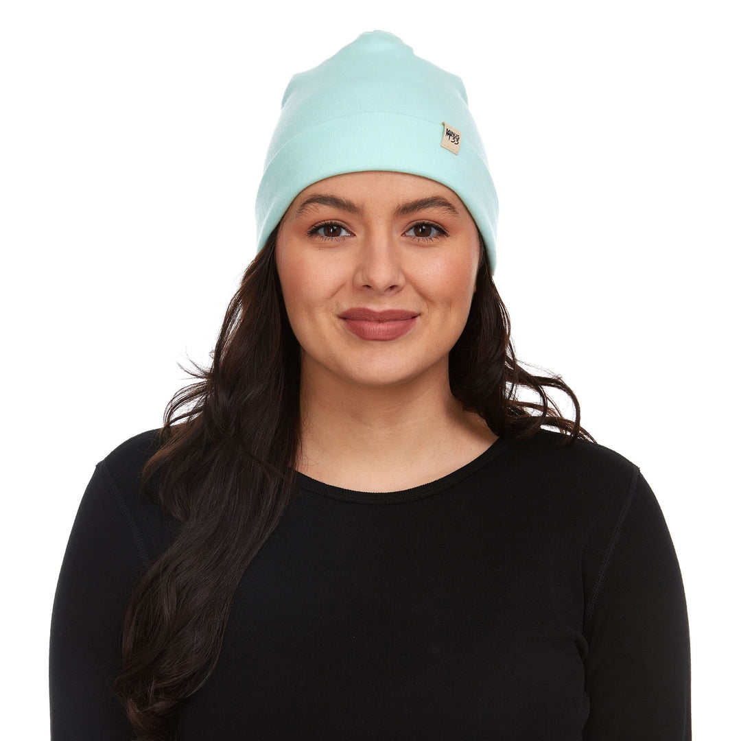 Head-and-shoulders front view of a model wearing a mint lightweight double-layer 100% merino wool beanie 