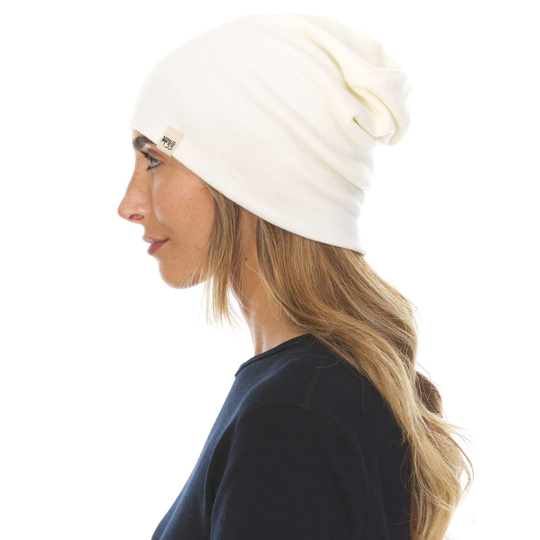 A woman models the lightweight, double-layered, hundred percent, super soft merino wool beanie perfect for fall, winter, and spring. This hat is perfect for a hike up the mountain or a walk around the block, right-facing side view 