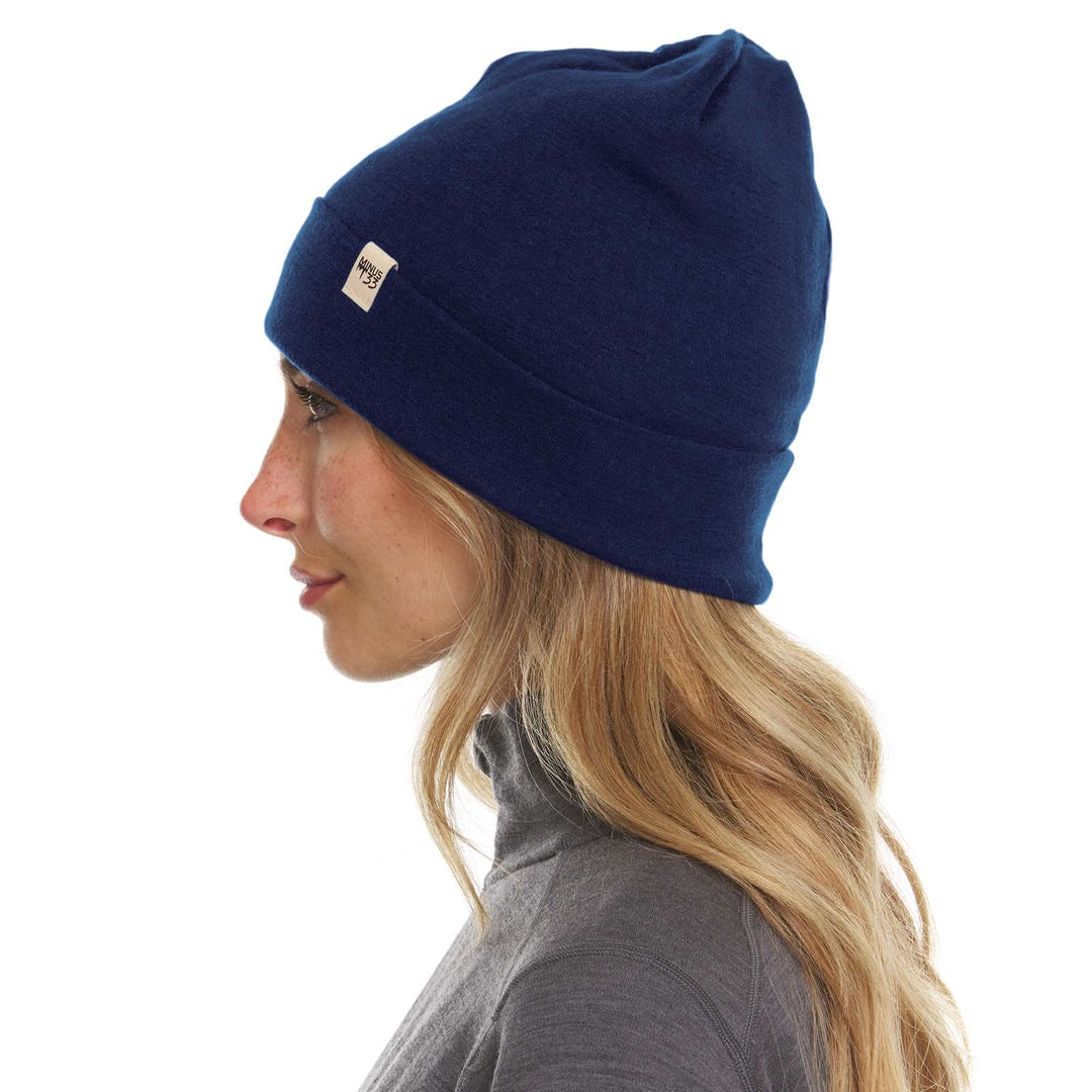 A woman models the lightweight, double-layered, hundred percent, super soft merino wool beanie perfect for fall, winter, and spring. This hat is perfect for a hike up the mountain or a walk around the block, right-facing side view 