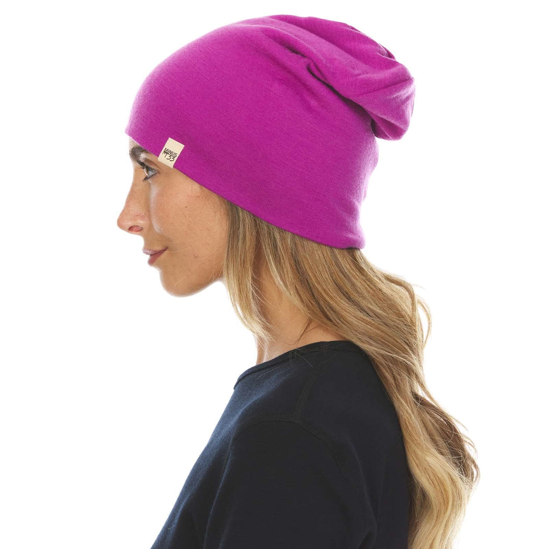 A woman models a lightweight, double-layered, hundred percent, super soft merino wool beanie perfect for fall, winter, and spring. This hat is perfect for a hike up the mountain or a walk around the block, right-facing side view 