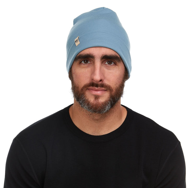 A man models the lightweight, double-layered, hundred percent, super soft merino wool beanie perfect for fall, winter, and spring. This hat is perfect for a hike up the mountain or a walk around the block!
