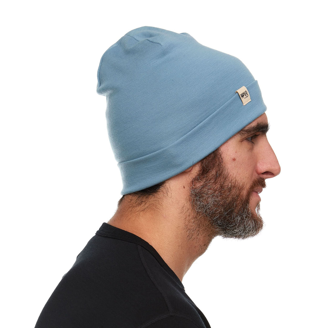 A man models the lightweight, double-layered, hundred percent, super soft merino wool beanie perfect for fall, winter, and spring. This hat is perfect for a hike up the mountain or a walk around the block, right-facing side view 