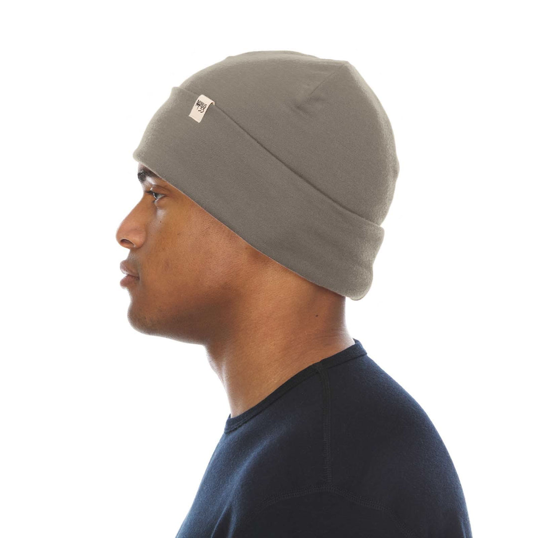 A man models the lightweight, double-layered, hundred percent, super soft merino wool beanie perfect for fall, winter, and spring. This hat is perfect for a hike up the mountain or a walk around the block, right-facing side view 