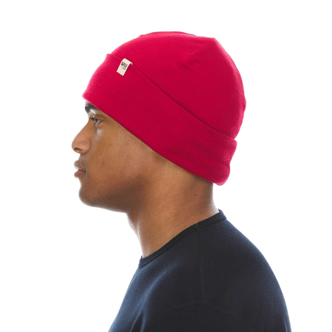 A man models a lightweight, double-layered, hundred percent, super soft merino wool beanie perfect for fall, winter, and spring. This hat is perfect for a hike up the mountain or a walk around the block, right-facing side view 