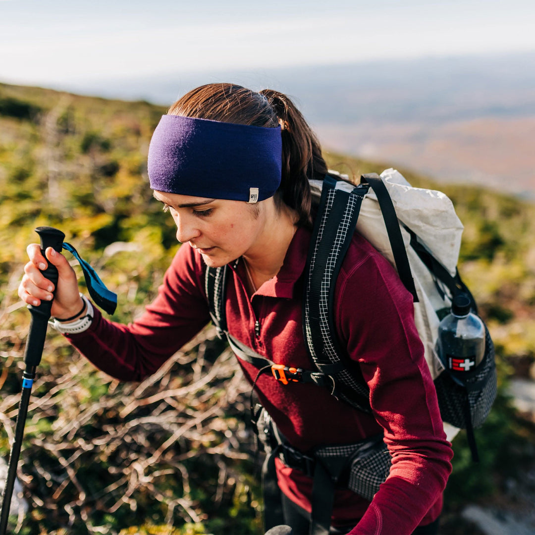 Minus33 Merino Wool Clothing Midweight Wool Reversible Headband, front three-quarter view outdoors with hands on hips