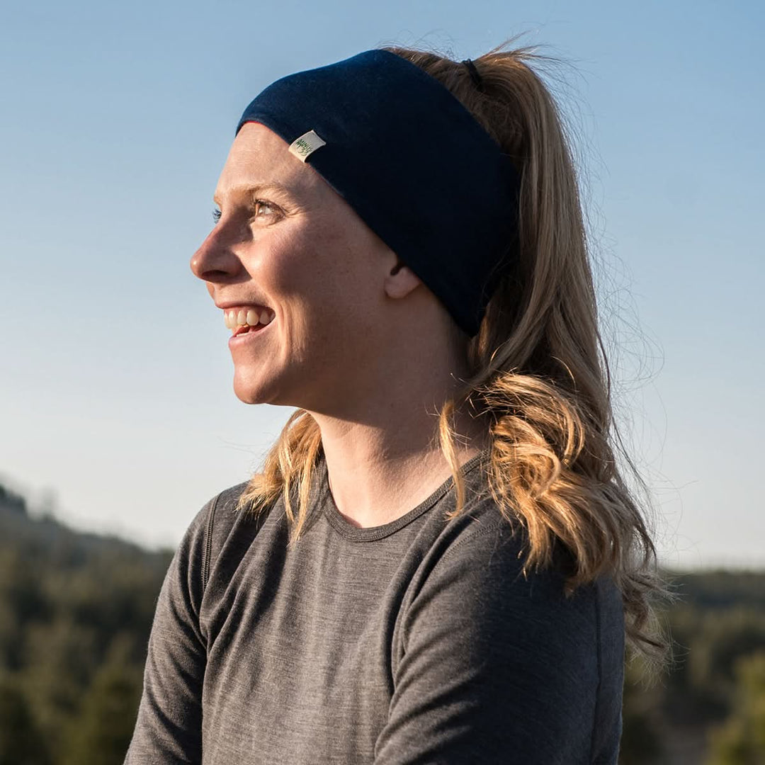 Midweight - Reversible Headband 100% Merino Wool - Minus33 Merino Wool Clothing, left-facing side view of a woman wearing the navy side in sunlight 