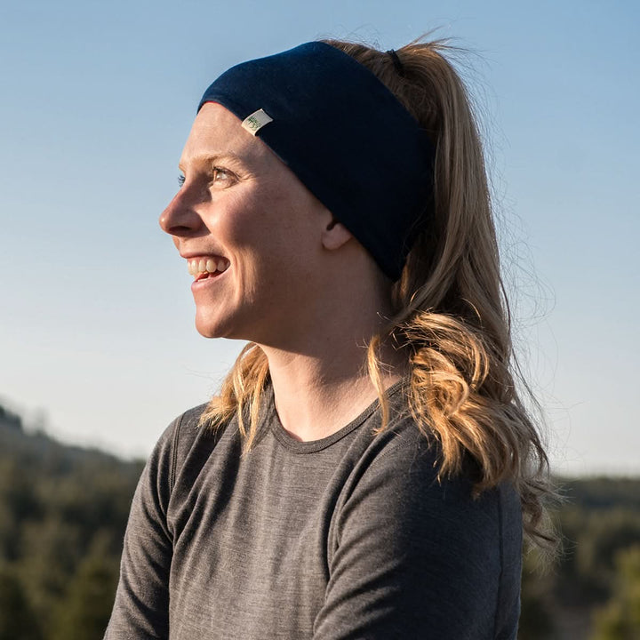 Midweight - Reversible Headband 100% Merino Wool - Minus33 Merino Wool Clothing, left-facing side view of a woman wearing the navy side in sunlight 