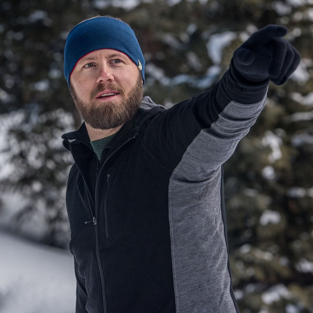 Midweight - Reversible Headband 100% Merino Wool - Minus33 Merino Wool Clothing, man wearing the navy side while pointing across a snowy landscape 