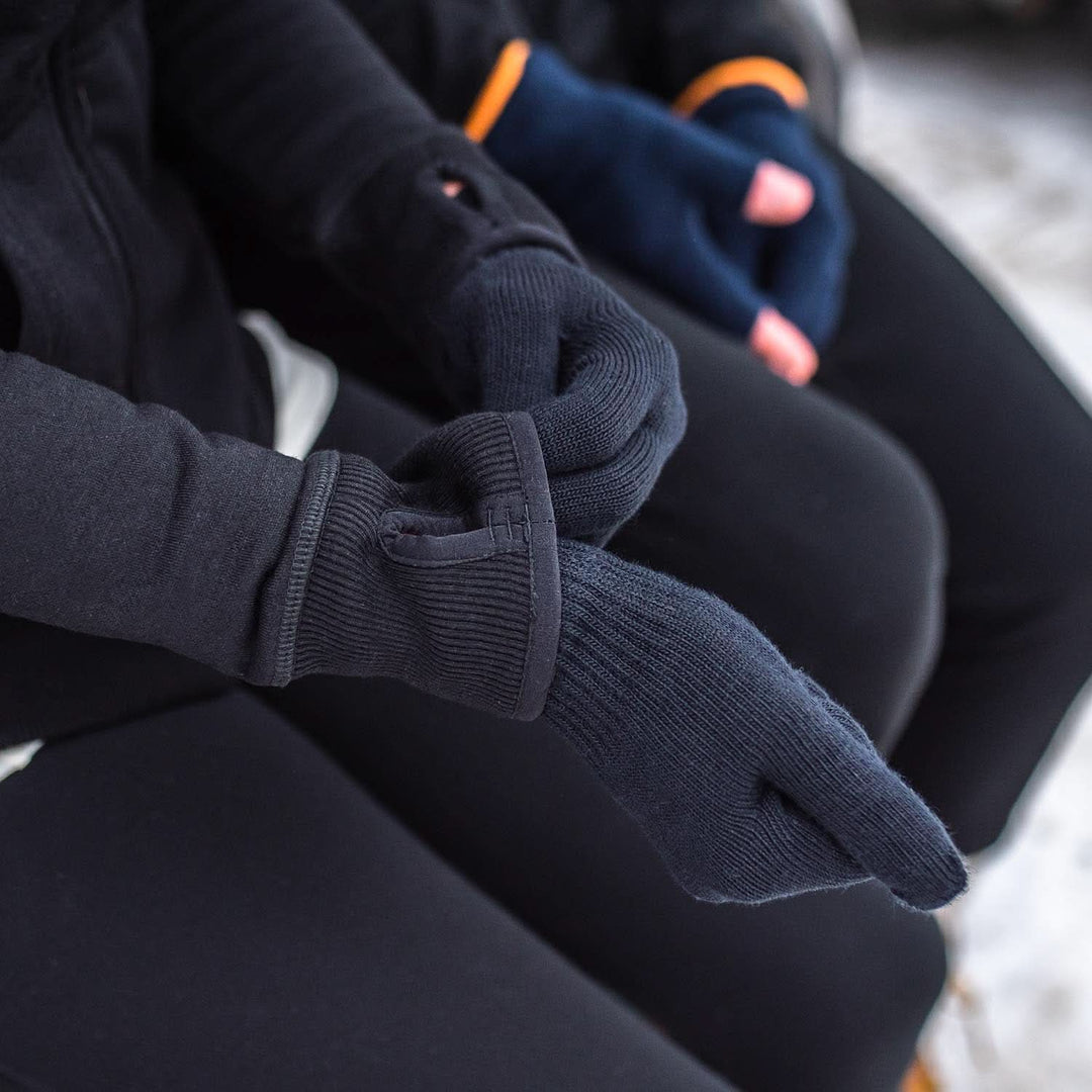 Person pulls a lightweight merino glove liner snug over the wrist 