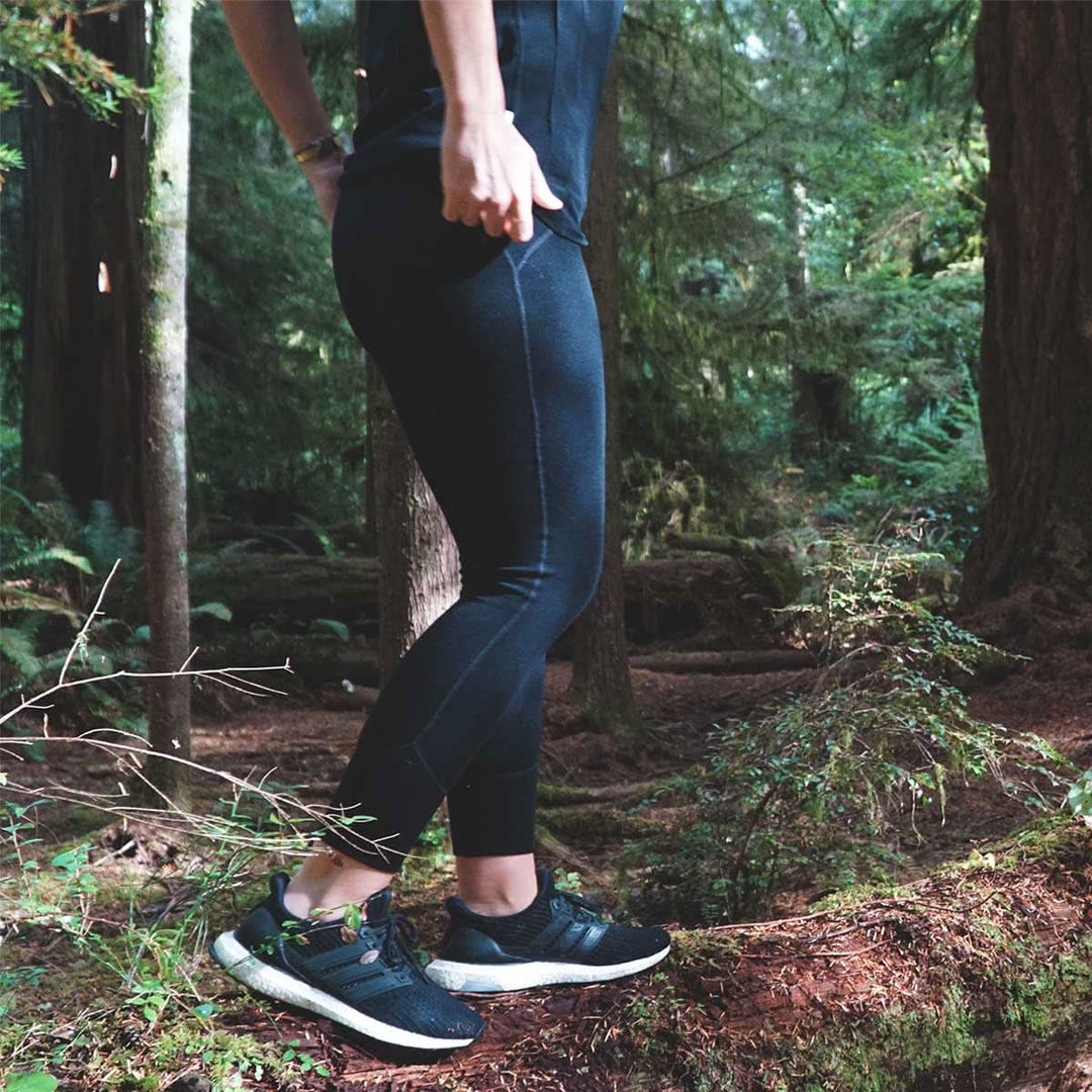 woman walking in the woods wearing minus33 heavyweight leggings 