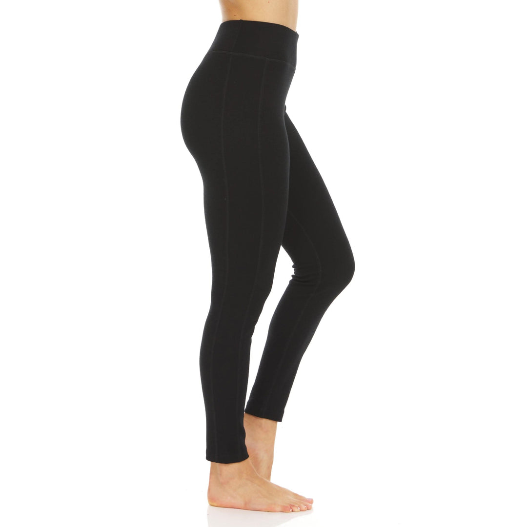 Left side view from waist to ankles of a woman wearing black Woolverino micro weight merino wool leggings, showing the wide waistband, smooth side panel, fitted full-length leg, and ankle hem