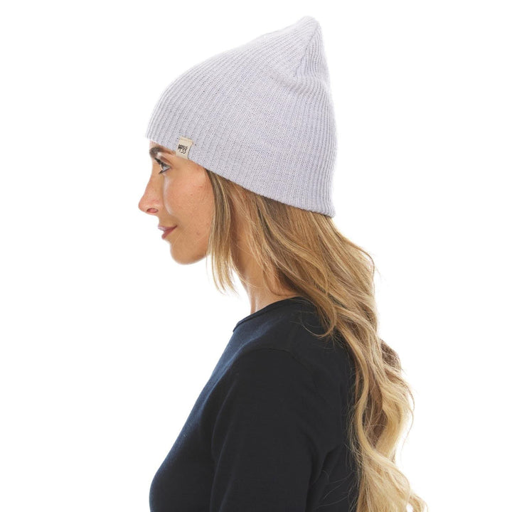 A woman models the midweight hundred percent merino wool beanie 